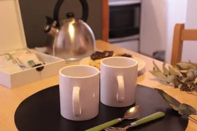 two white mugs sitting on top of a table at DEPTO EN VILLA GRAL BELGRANO in Villa General Belgrano