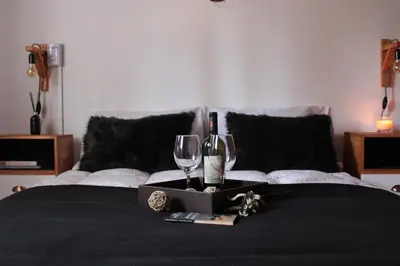 a bed with two wine glasses and a box on it at DEPTO EN VILLA GRAL BELGRANO in Villa General Belgrano