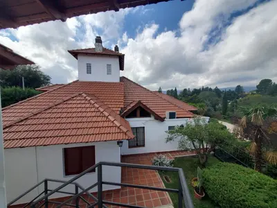 a white house with a red roof at Cabañas Las Pencas in Mina Clavero
