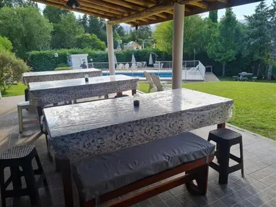 a patio with two tables and two stools at Cabañas Las Pencas in Mina Clavero