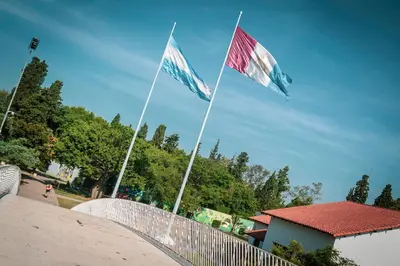 two flags are flying over a white fence at Las Tejas in Cordoba