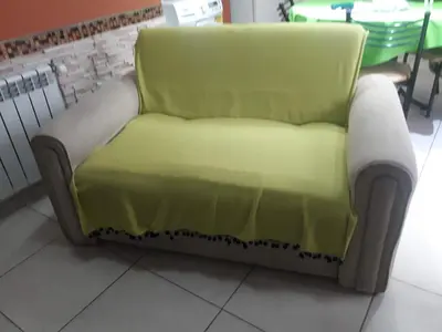 a green couch sitting on the floor in a room at Departamento Entre Rios in Villa Carlos Paz