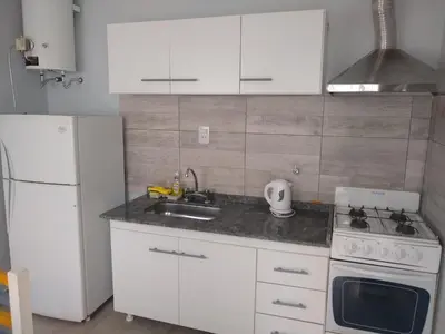 a kitchen with white cabinets and a sink and a refrigerator at PINZON 1984 in Cordoba