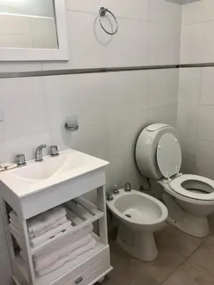 a white bathroom with a toilet and a sink at PINZON 1984 in Cordoba