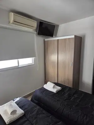 a bedroom with two beds and a cabinet and a fan at PINZON 1984 in Cordoba