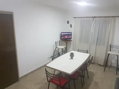 a room with a table and chairs and a television at Departamento a estrenar excelente ubicacion, 1 cuadra de la terminal in Cordoba