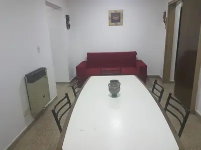 a room with a white table and a red couch at Departamento a estrenar excelente ubicacion, 1 cuadra de la terminal in Cordoba
