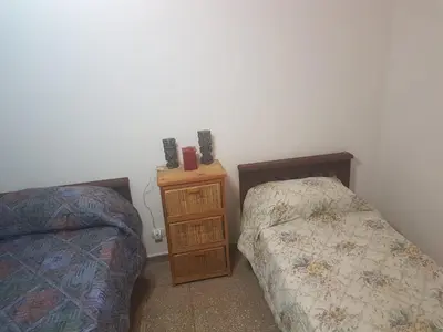 a bedroom with two beds and a night stand with speakers at Departamento a estrenar excelente ubicacion, 1 cuadra de la terminal in Cordoba
