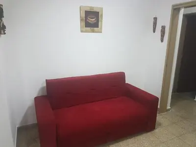 a red couch sitting in a corner of a room at Departamento a estrenar excelente ubicacion, 1 cuadra de la terminal in Cordoba