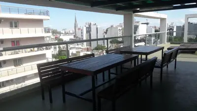 two tables and chairs on a balcony with a view of a city at DPTO ALTA CORDOBA in Cordoba