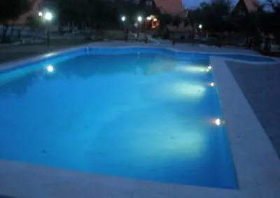 a large swimming pool at night with lights in it at Cabañas Ayres del cerro in Merlo
