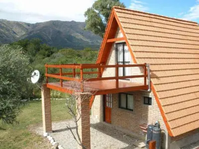 a house with a balcony on the side of it at Cabañas Ayres del cerro in Merlo