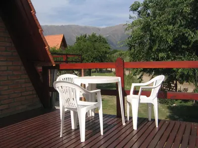 a white table and two chairs on a deck at Cabañas Ayres del cerro in Merlo