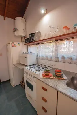 a kitchen with a stove and a sink at Cabañas Dalga Inn in Merlo