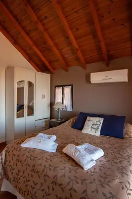 a bedroom with a large bed with two towels on it at Cabañas Dalga Inn in Merlo