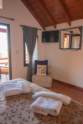 a bedroom with a bed and a couch in it at Cabañas Dalga Inn in Merlo