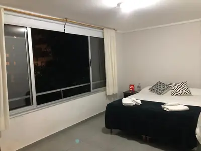 a bedroom with a bed and a large window at LitStay Laprida in Cordoba
