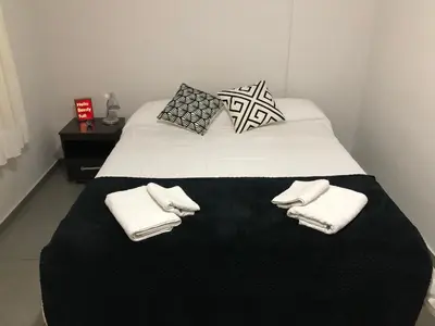 a white bed with two pillows and towels on it at LitStay Laprida in Cordoba