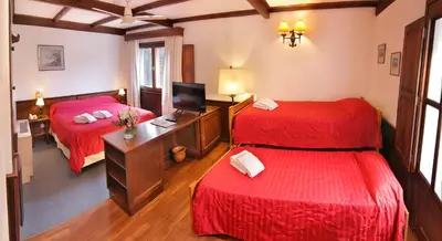 a hotel room with two beds and a television at Bremen Hotel & Spa in Villa General Belgrano