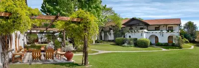 a house with a table and chairs in a yard at Bremen Hotel & Spa in Villa General Belgrano