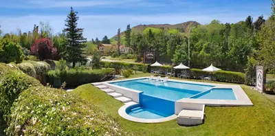 a swimming pool in the middle of a garden at Bremen Hotel & Spa in Villa General Belgrano
