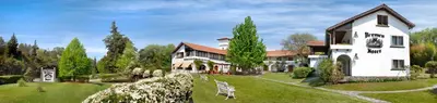 a large white house with a yard with a bench at Bremen Hotel & Spa in Villa General Belgrano