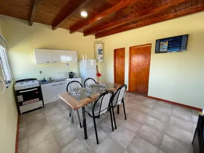 a kitchen with a table and chairs in a kitchen at Cabañas PAIGÜEN in Villa Yacanto