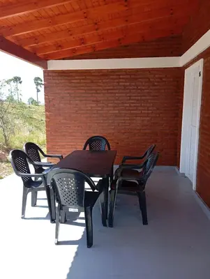 a wooden table and chairs on a patio at Cabañas PAIGÜEN in Villa Yacanto