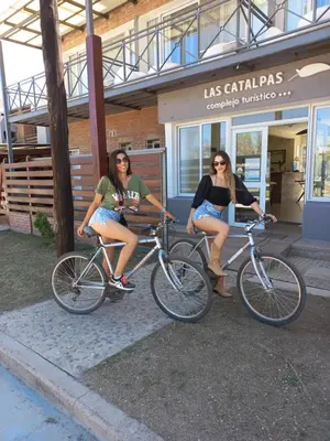 two women sitting on bikes in front of a store at Complejo Turístico Las Catalpas in Mina Clavero