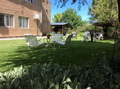 a yard with chairs and a table and a playground at Complejo Turístico Las Catalpas in Mina Clavero