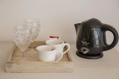 a tray with cups and a coffee maker and wine glasses at Complejo Turístico Las Catalpas in Mina Clavero