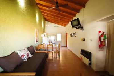 a living room with a couch and a dining room at Complejo Turístico Las Catalpas in Mina Clavero