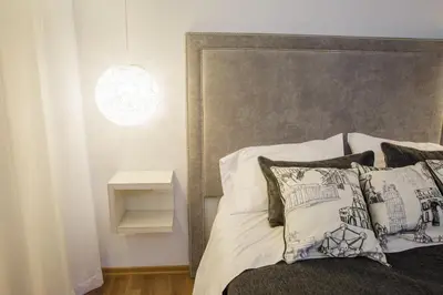 a bedroom with a bed with a gray headboard and pillows at Complejo Turístico Las Catalpas in Mina Clavero