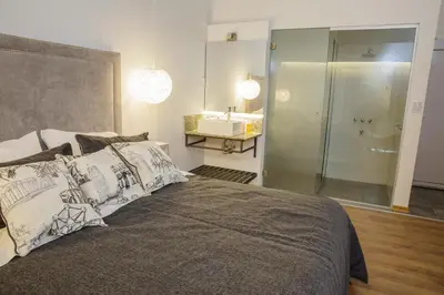 a bedroom with a bed and a bathroom with a sink at Complejo Turístico Las Catalpas in Mina Clavero