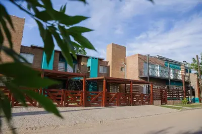 a building with a fence in front of it at Complejo Turístico Las Catalpas in Mina Clavero