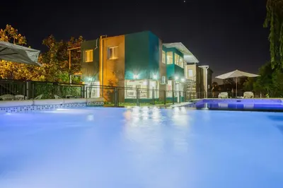 a swimming pool in front of a house at night at Complejo Turístico Las Catalpas in Mina Clavero