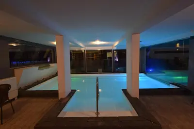 a swimming pool in a building with columns at Piazza Hotel in Villa Carlos Paz