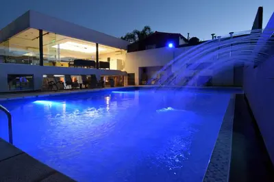 a swimming pool with a water fountain in front of a building at Piazza Hotel in Villa Carlos Paz
