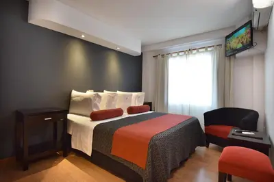 a hotel room with a bed and a chair at Piazza Hotel in Villa Carlos Paz