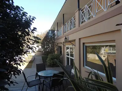 a patio with a table and chairs next to a building at Casa Nostra Hotel in Villa Carlos Paz