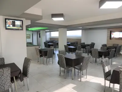 a dining room with black tables and chairs at Casa Nostra Hotel in Villa Carlos Paz
