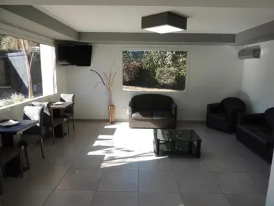 a living room with a couch and chairs and a table at Casa Nostra Hotel in Villa Carlos Paz