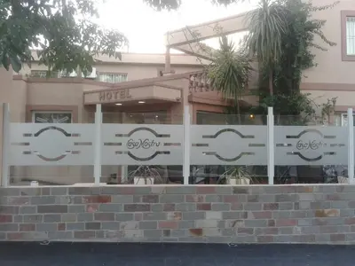 a white fence in front of a building at Casa Nostra Hotel in Villa Carlos Paz