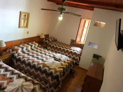 a room with three beds in a room at Hotel Marengo in Mina Clavero