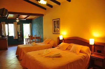 two beds in a room with yellow walls at Tico Tico Apart in Mina Clavero