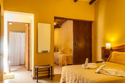 a bedroom with yellow walls and a bed with a mirror at Tico Tico Apart in Mina Clavero