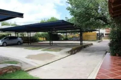 a parking lot with a car parked under a canopy at Tico Tico Apart in Mina Clavero