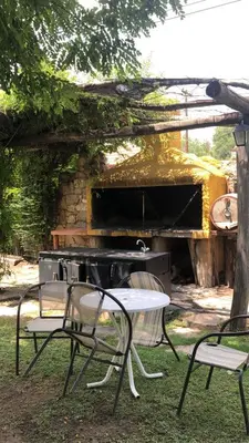 a table and chairs in front of a grill at Tico Tico Apart in Mina Clavero