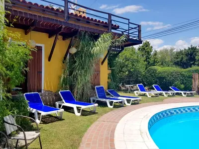 a group of blue lounge chairs next to a pool at Tico Tico Apart in Mina Clavero