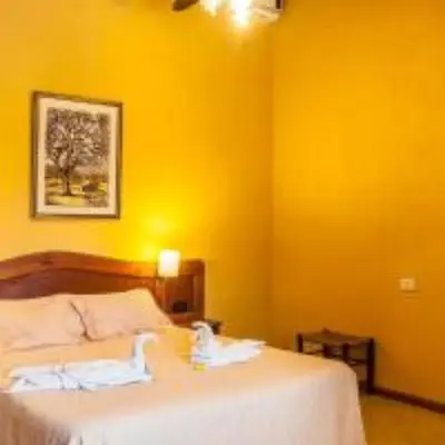a bedroom with a bed with a yellow wall at Tico Tico Apart in Mina Clavero
